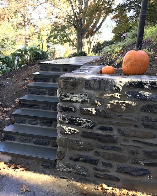 Picture of a stone wall and steps up to a house